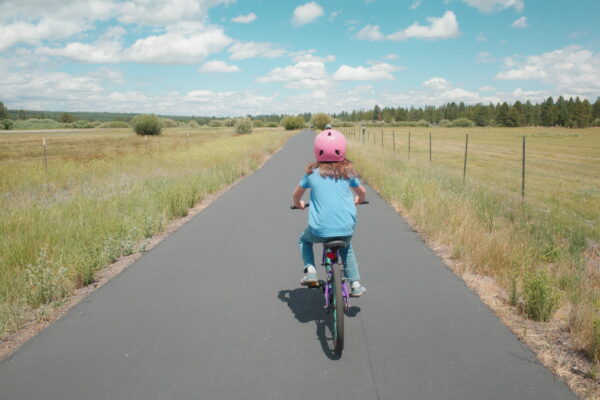 Child riding a bike along a paved trail in Sunriver Oregon