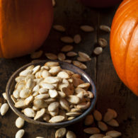 A tray of roasted pumpkin seeds fresh out of the oven, golden and seasoned.