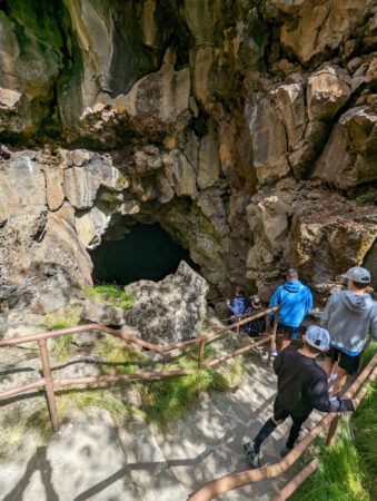 Family walking down steps into Lava River Cave in Oregon